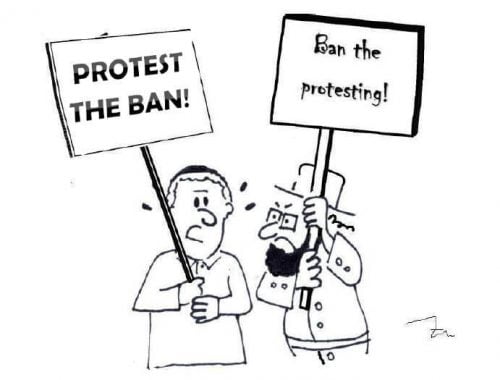 Somone holding a sign saying "protest the ban" while a Hasidic Jew holds a sign saying "ban the protest"